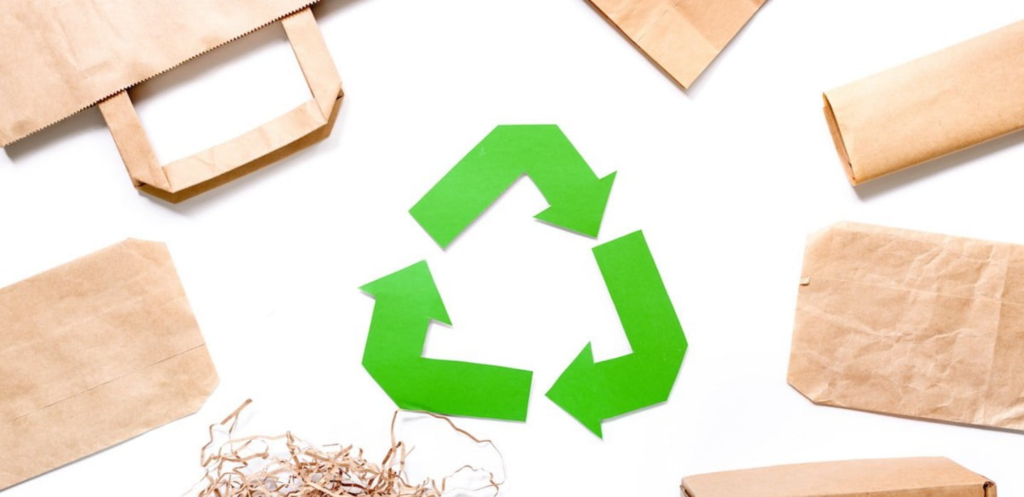 Symbol recyklácie a papierové obaly, akcentujúcú ekologický prístup k oralnej hygiene
