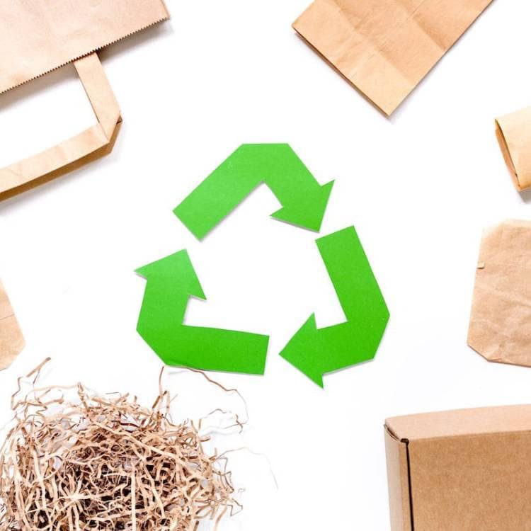 Symbol recyklácie a papierové obaly, akcentujúcú ekologický prístup k oralnej hygiene